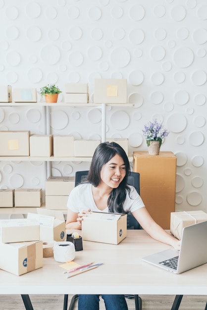 Proprietario di una piccola impresa, donna che controlla l'ordine di acquisto nel computer portatile