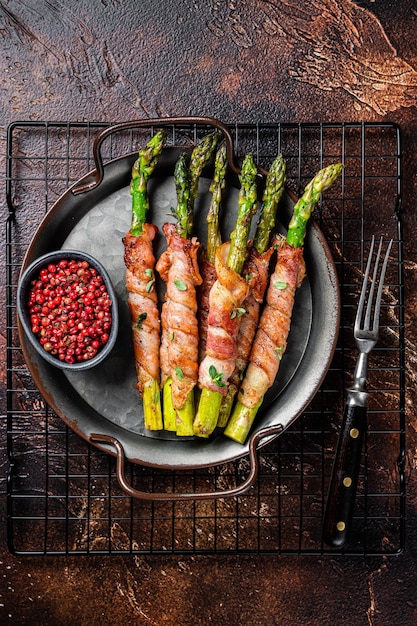 Prosciutto al forno avvolto asparagi verdi Sfondo scuro Vista dall'alto