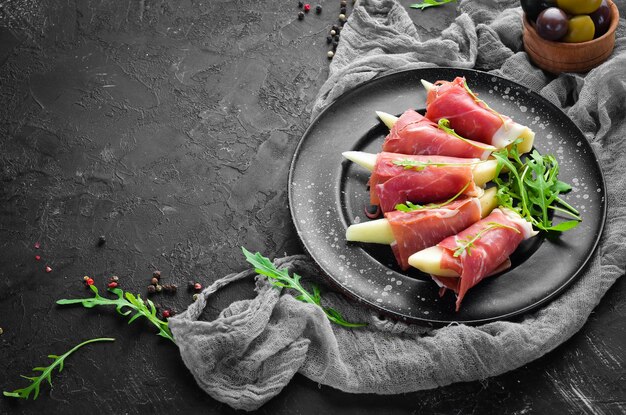 Prosciutto con pere e rucola. Spuntini freddi. Vista dall'alto. Spazio libero per il tuo testo.