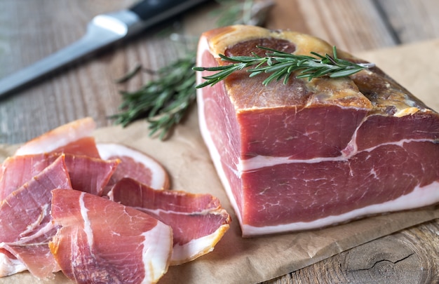 Prosciutto con rosmarino fresco sulla tavola di legno