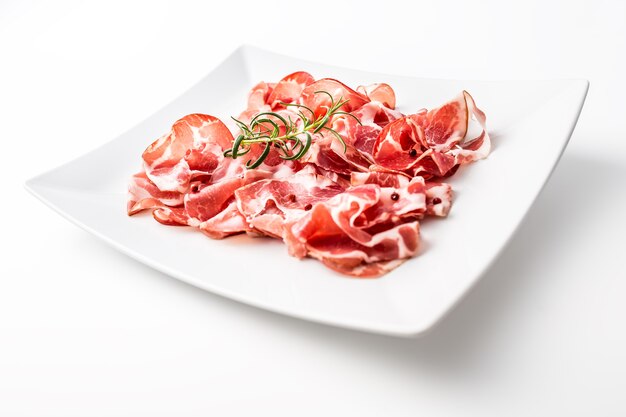 Prosciutto. Fette arricciate di delizioso prosciutto italiano al rosmarino.