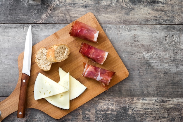 Prosciutto serrano spagnolo e formaggio su una tavola di legno rustica