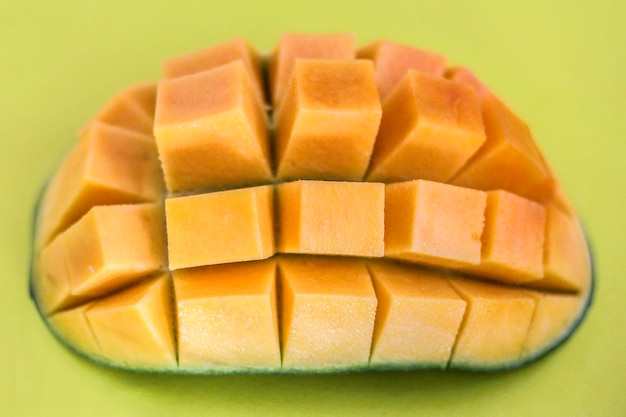 Prossimo piano ad alto angolo di mango affettato sullo sfondo verde