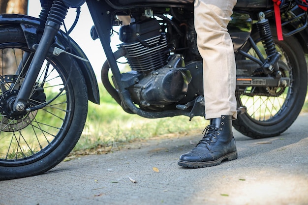 Prossimo piano dei motociclisti piede e ruote di motocicletta d'epoca
