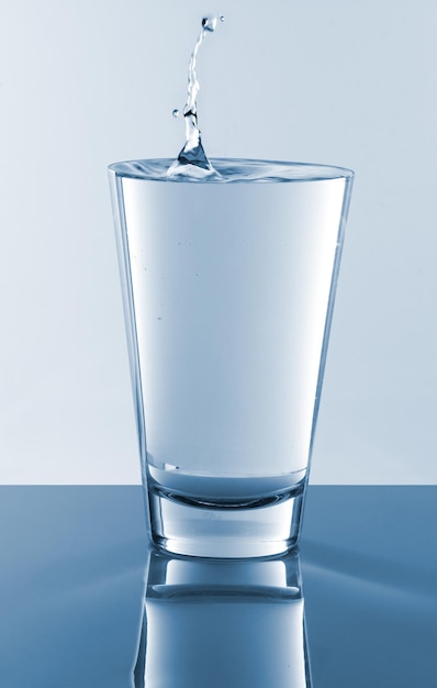 Prossimo piano dell'acqua nel bicchiere contro uno sfondo bianco