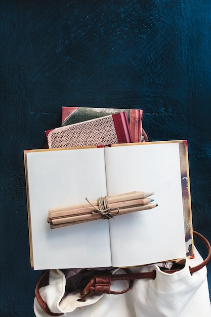 Prossimo piano della borsa e dei libri sul tavolo
