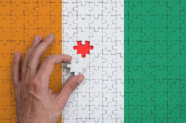 Prossimo piano di una mano che organizza i pezzi del puzzle