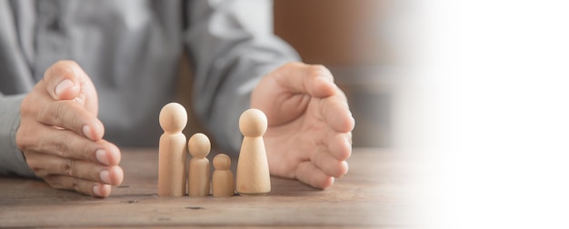 Proteggere le mani la bambola di legno della famiglia per la pianificazione assicurativa