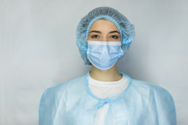 Protezione contro le malattie contagiose, coronavirus. Medico femminile che indossa maschera medica chirurgica facciale igienica. Banner panorama personale medico equipaggiamento preventivo. Studio fotografico, malattia