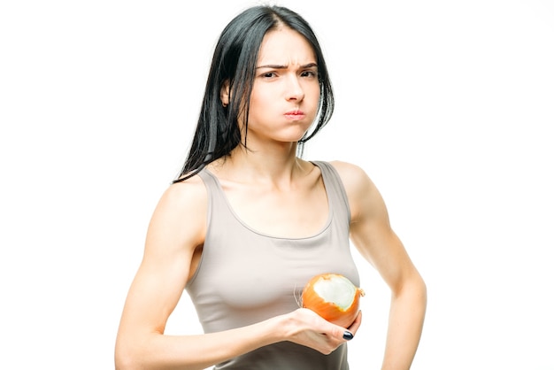 Protezione da raffreddore, moccio e influenza, la donna mangia cipolla su bianco.