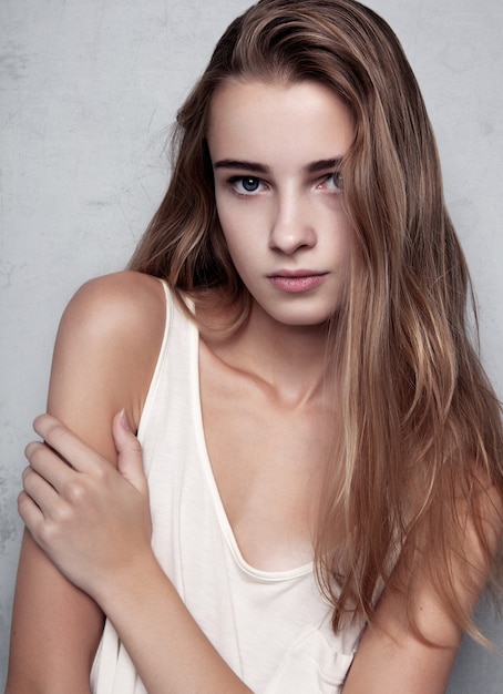 Prova di modello con la giovane bella modella che indossa t-shirt bianca in studio. Ritratto a colori