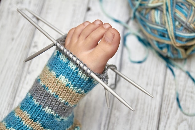 Prova un calzino su un piede del bambino mentre lavori a maglia