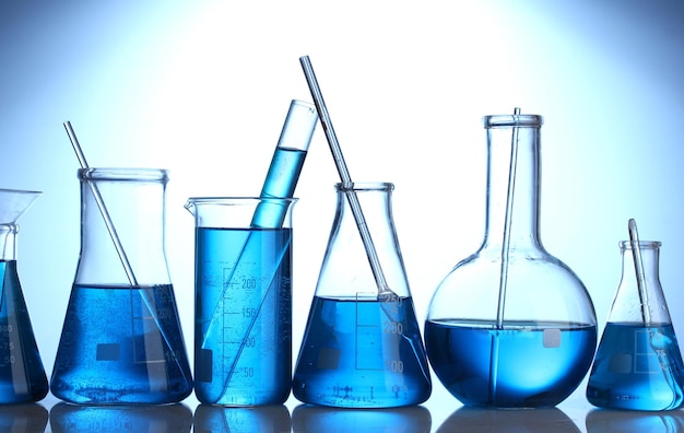Provette con liquido blu su sfondo blu