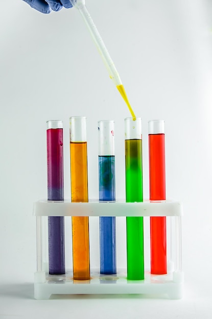 Provette con reagenti multicolori su sfondo bianco. chimica, esperimenti