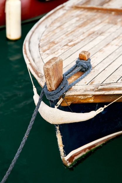 Prua di una barca di legno con un primo piano attaccato alla fune di ancoraggio