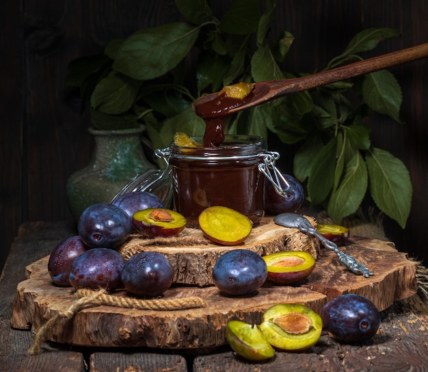 prugne blu mature e marmellata di prugne sul tavolo