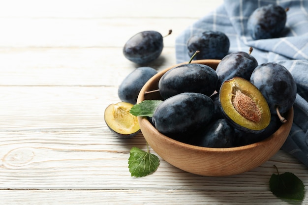 Prugne fresche e foglie sul tavolo