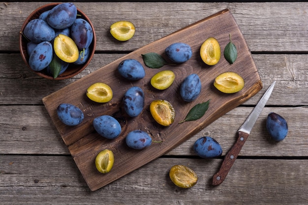 Prugne fresche in ciotola su tavolo di legno sfondo di frutta