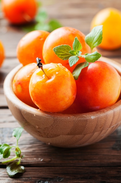 Prugne gialle fresche dolci sulla tavola di legno