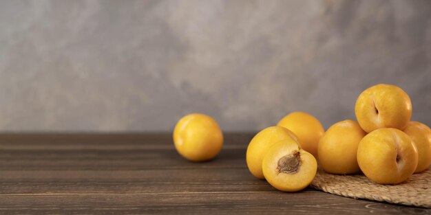 Prugne gialle su uno sfondo di legno Frutta fresca BIO