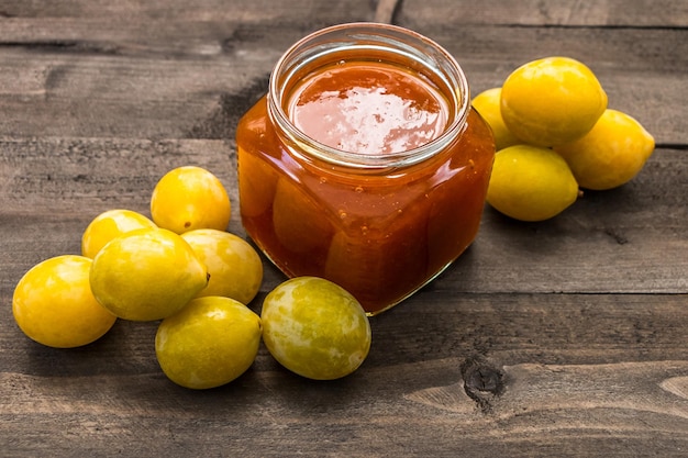 Prugne gialle sul tavolo e un vasetto di marmellata di prugne