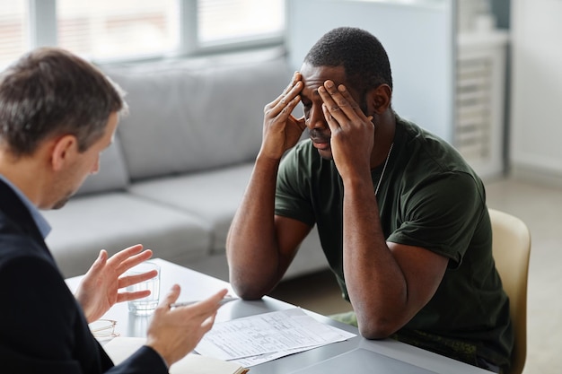 Psichiatra professionista che ha una sessione di terapia con un giovane militare afroamericano con disturbo da stress post-traumatico