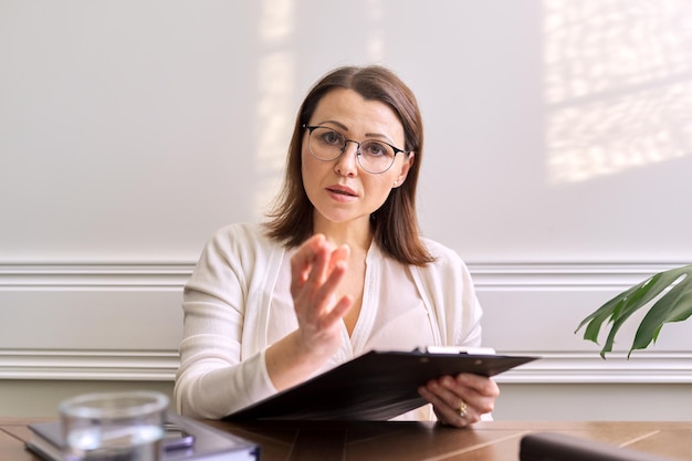 Psicologa, psichiatra che guarda la tavoletta digitale della webcam. Videoconferenza, colloquio specialistico, consulenza, assistenza al paziente online. Tecnologia, medicina, assistenza sanitaria, concetto di persone