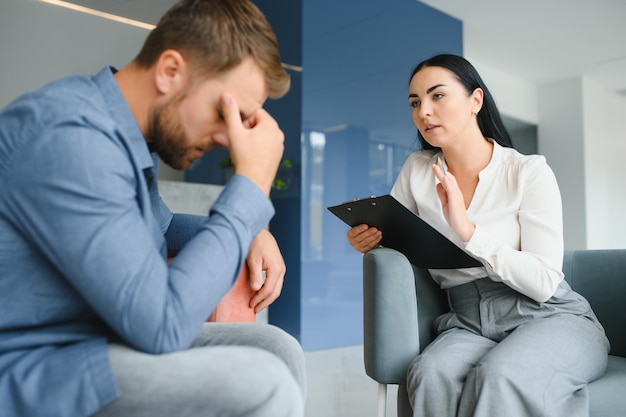 Psicologia terapia mentale e concetto di persone donna psicologa che parla con un giovane triste paziente alla sessione di psicoterapia