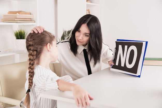 Psicologo femminile che consiglia bambina nel gabinetto.