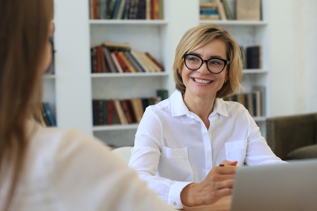 Psicologo femminile di mezza età professionale che conduce una consultazione.