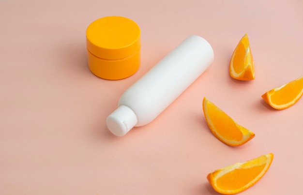 Pubblicità di cosmetici energetici naturali agli agrumi per la cura della pelle con ingredienti freschi naturali di pubblicità colorata con estratto di arancia.