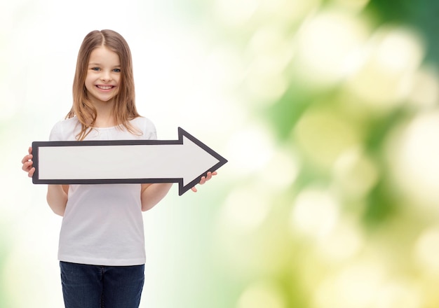 pubblicità e concetto di bambino - bambina sorridente con la freccia in bianco che punta a destra