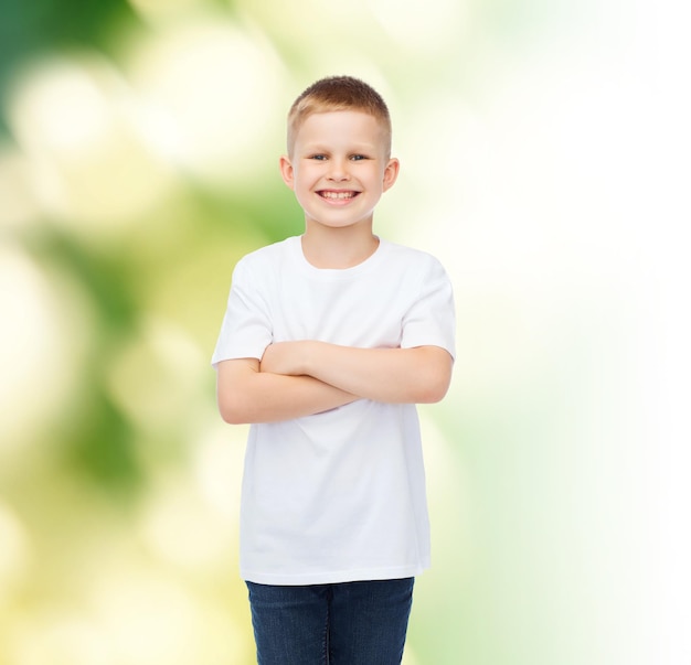 pubblicità, ecologia, persone e concetto di infanzia - ragazzino sorridente in t-shirt bianca vuota su sfondo verde