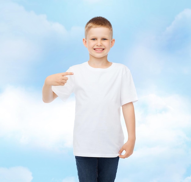 pubblicità, gesto, persone e concetto di infanzia - ragazzo sorridente in t-shirt bianca che punta il dito su se stesso su sfondo con cielo nuvoloso
