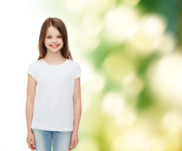 pubblicità, infanzia, ecologia e persone - bambina sorridente in maglietta bianca bianca su sfondo verde