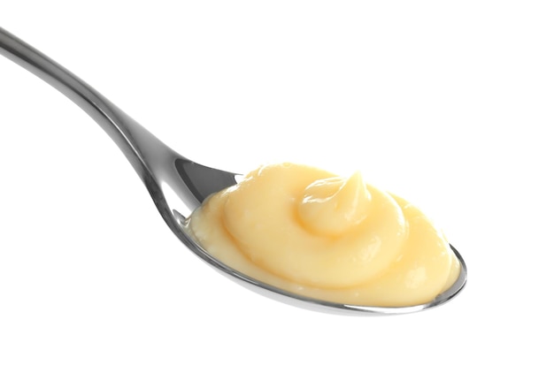 Pudding di vaniglia gustoso in cucchiaio su sfondo bianco