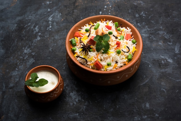 Pulav o Biryani di verdure indiane a base di riso basmati, servite in una ciotola di terracotta. messa a fuoco selettiva