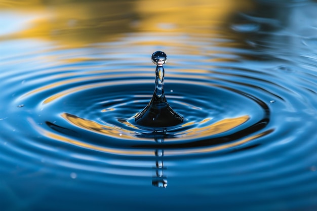 Pulisca la goccia blu lucida con i cerchi sull'acqua chiuda sulla vista frontale