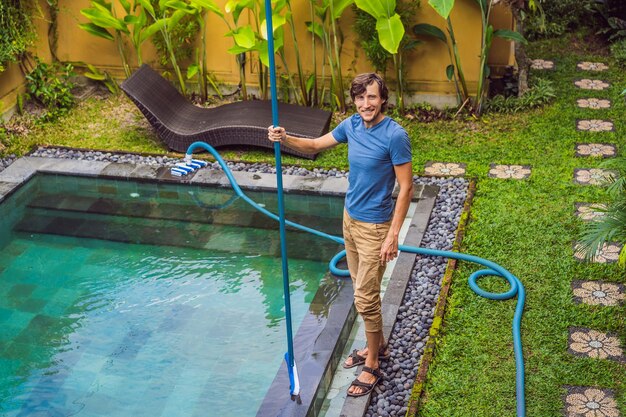 Pulitore della piscina Uomo in camicia blu con attrezzature per la pulizia delle piscine Servizi di pulizia della piscina