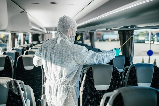 Pulizia chimica professionale dei sedili degli autobus. Disinfezione autobus. Sterminatore in abiti da lavoro.