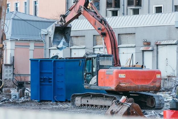 Pulizia dei detriti di costruzione con una benna di un escavatore, l'escavatore carica i resti