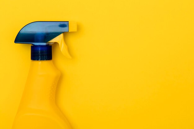 Pulizia dei prodotti in bottiglia spray su uno sfondo giallo brillante