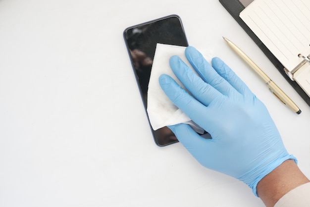 pulizia del display del telefono cellulare per prevenire virus sul tavolo