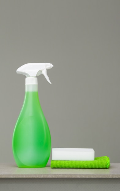 Pulizia del flacone spray verde con dispenser in plastica, spugna e panno per la polvere