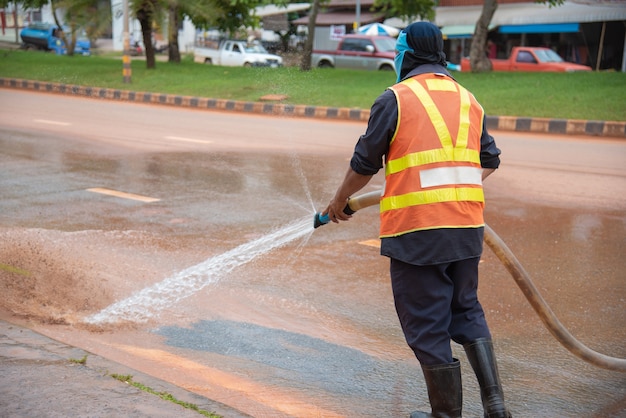 Pulizia dell&#39;acqua del lavoratore dopo un mercato di strada.