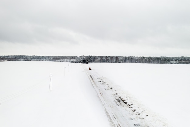 Pulizia della neve dalle strade dopo una forte nevicata. Il trattore pulisce la vista della neve dall'alto.