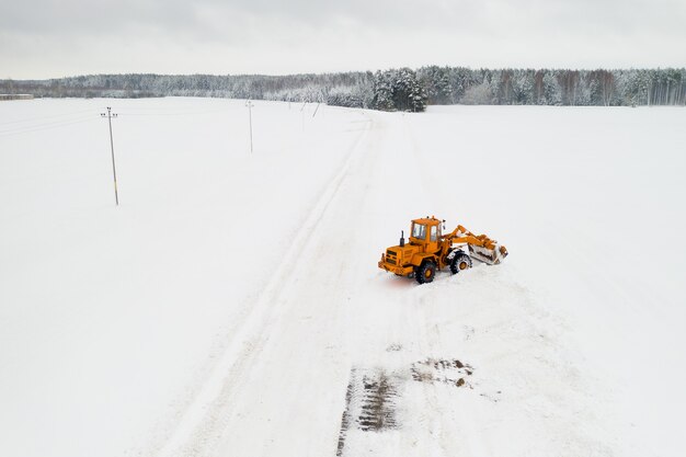 Pulizia della neve dalle strade dopo una forte nevicata. Il trattore pulisce la vista della neve dall'alto.