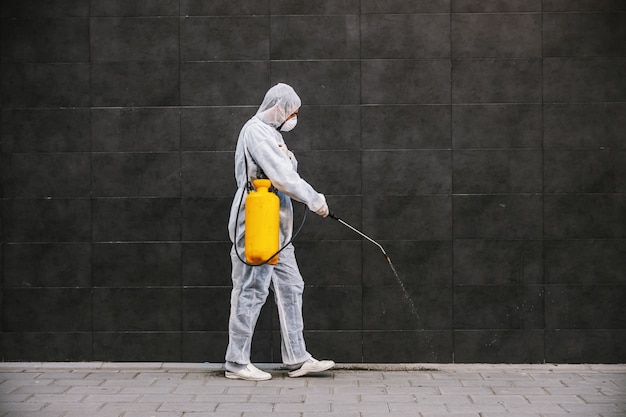 Pulizia e disinfezione all'esterno intorno agli edifici, l'epidemia di covid-19. squadre di sessione per gli sforzi di disinfezione. Prevenzione delle infezioni e controllo dell'epidemia. e vestito e maschera.