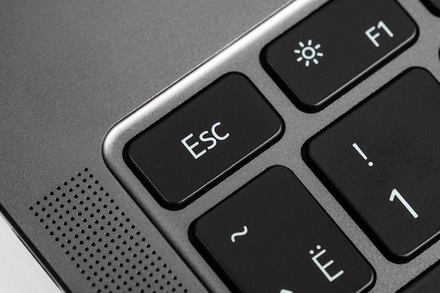 pulsanti della tastiera e frammenti di laptop su sfondo nero e argento