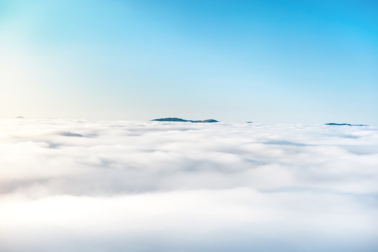 Photo puncak gunung hijau di lautan awan